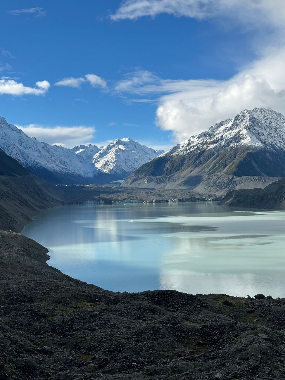Beautiful clear alpine lake reflecting snowy peak